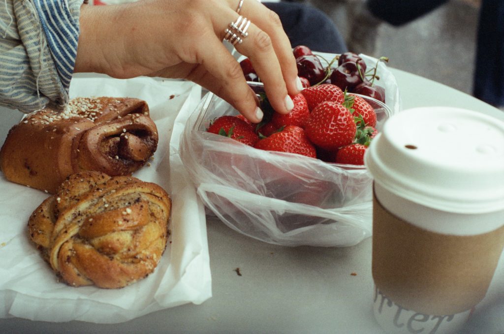 photo of a hand with some buns, strawberries and cherries. phptp credit Chanelle Allesandre