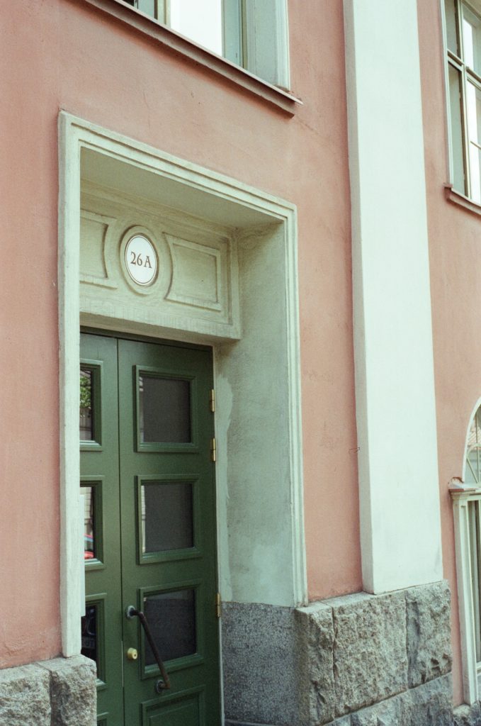 photo of a green door on a dusty pink building. photo credit Chanelle Allesandre.