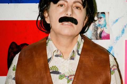 photo of Juliana Irene Smith wearing a black wig and a fake moustache
