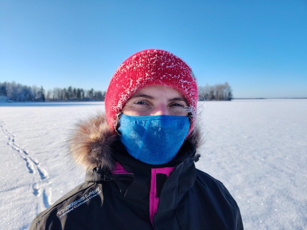 Mareike Dobewall on a wintery lake with frost in her hair, wearing a beanie and balaclava