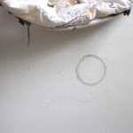 photo of a concrete surface with a ring-shaped stain on it, and some fabrics