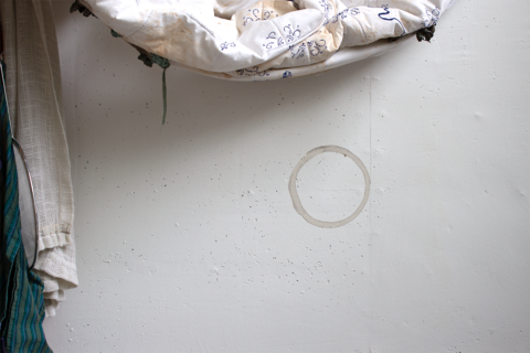 photo of a concrete surface with a ring-shaped stain on it, and some fabrics