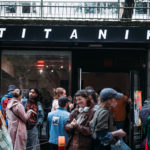 people standing and talking in front of Titanik