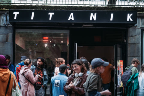 people standing and talking in front of Titanik